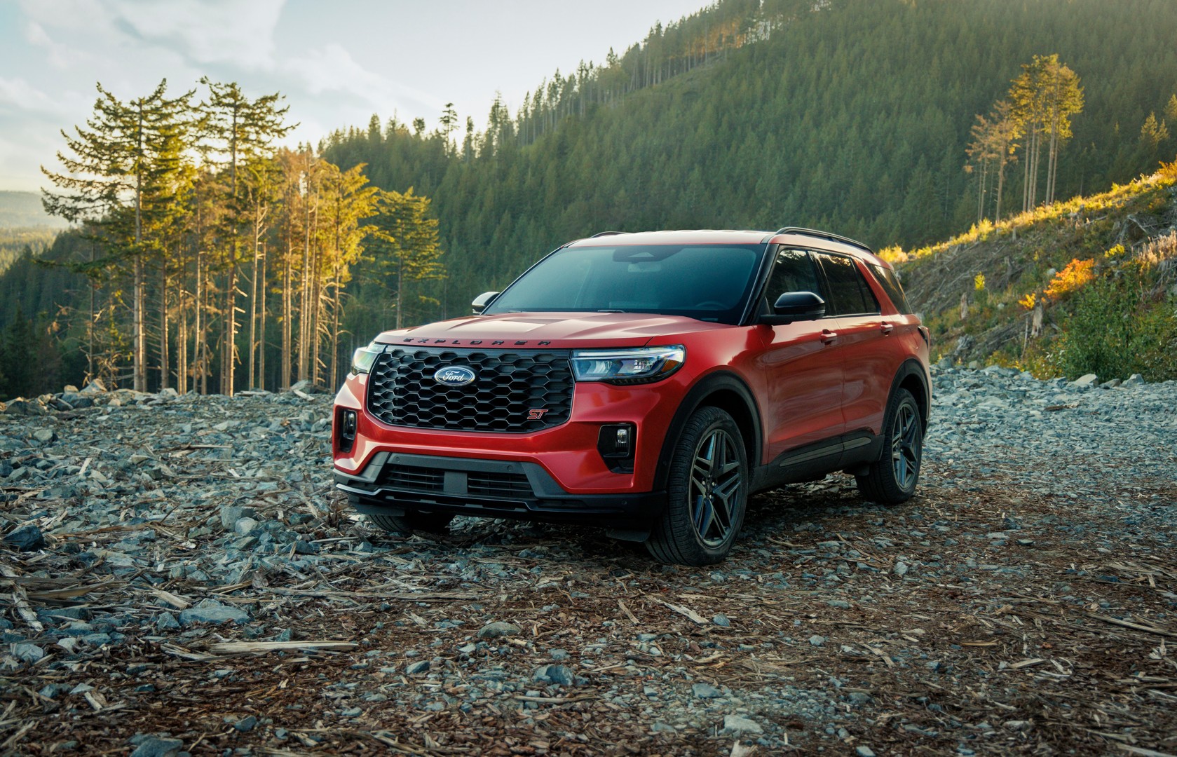 Red Ford Explorer on a rocky forest road.